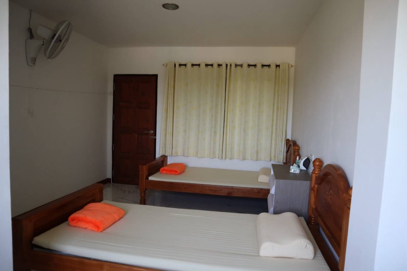 Room with a single bed and fan